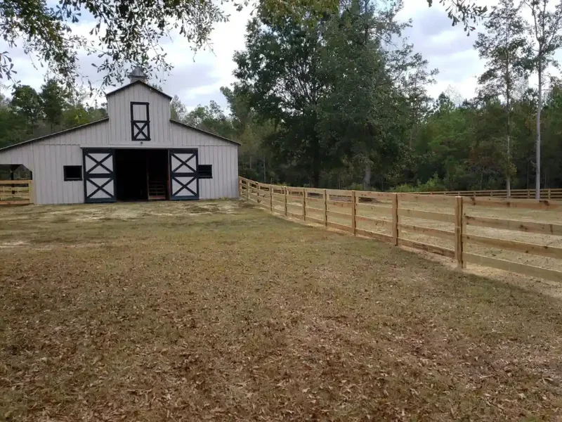 Barn and wooden rail fence on open rural property